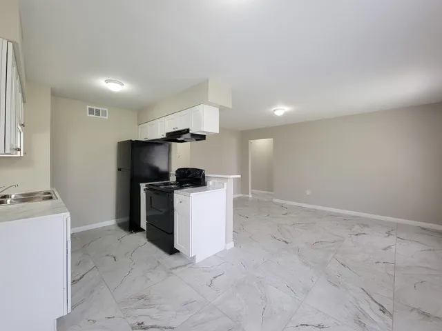 a view of kitchen with furniture and refrigerator