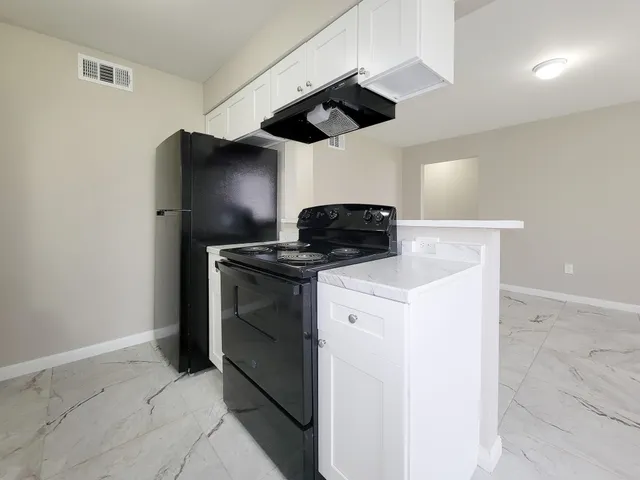 a kitchen with stainless steel appliances granite countertop a sink a stove and a refrigerator