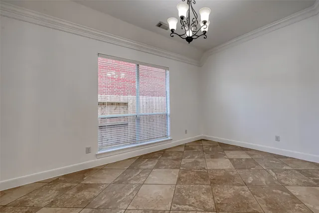 an empty room with wooden floor fireplace and windows