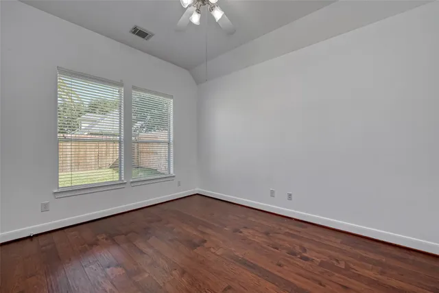a view of an empty room with wooden floor