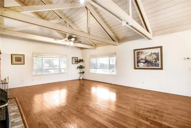 a view of a hallway with wooden floors and fireplace