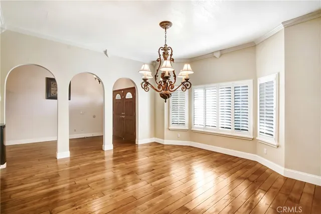 a view of a room with wooden floor chandelier and a window
