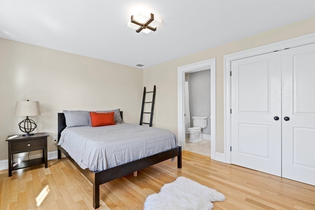 5 Cider Circle Bolton, MA 01740 - Photo 28 of 42 a bedroom with a bed and a chandelier