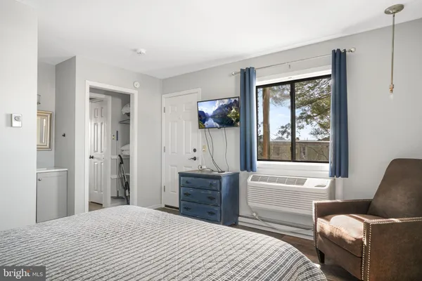 a bedroom with a bed and a window with couch