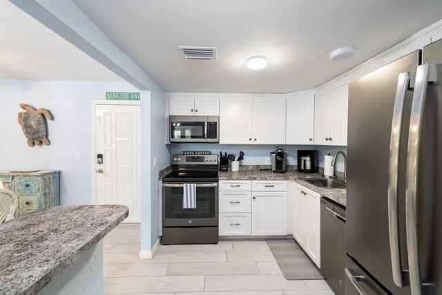 a kitchen with granite countertop stainless steel appliances and refrigerator