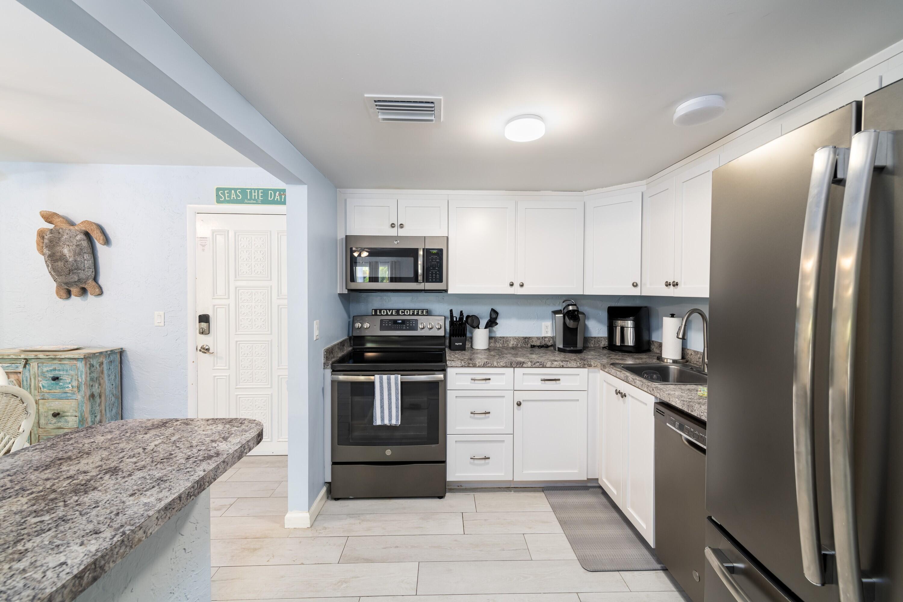 105 Ave D, Unit 101 Marathon, FL 33050 - Photo 13 of 32 a kitchen with a sink stove and refrigerator