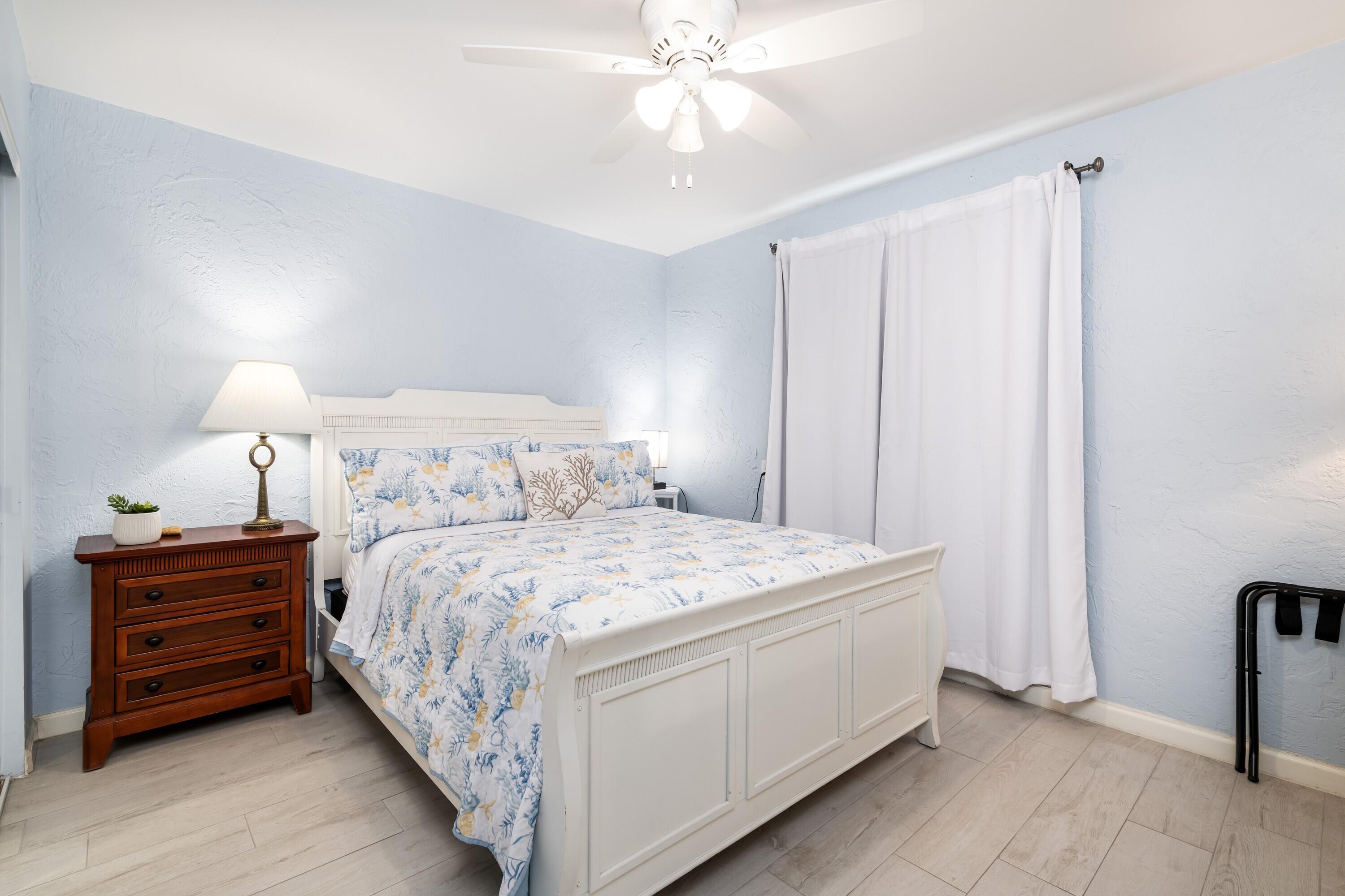 105 Ave D, Unit 101 Marathon, FL 33050 - Photo 17 of 32 a bedroom with a bed and a chandelier