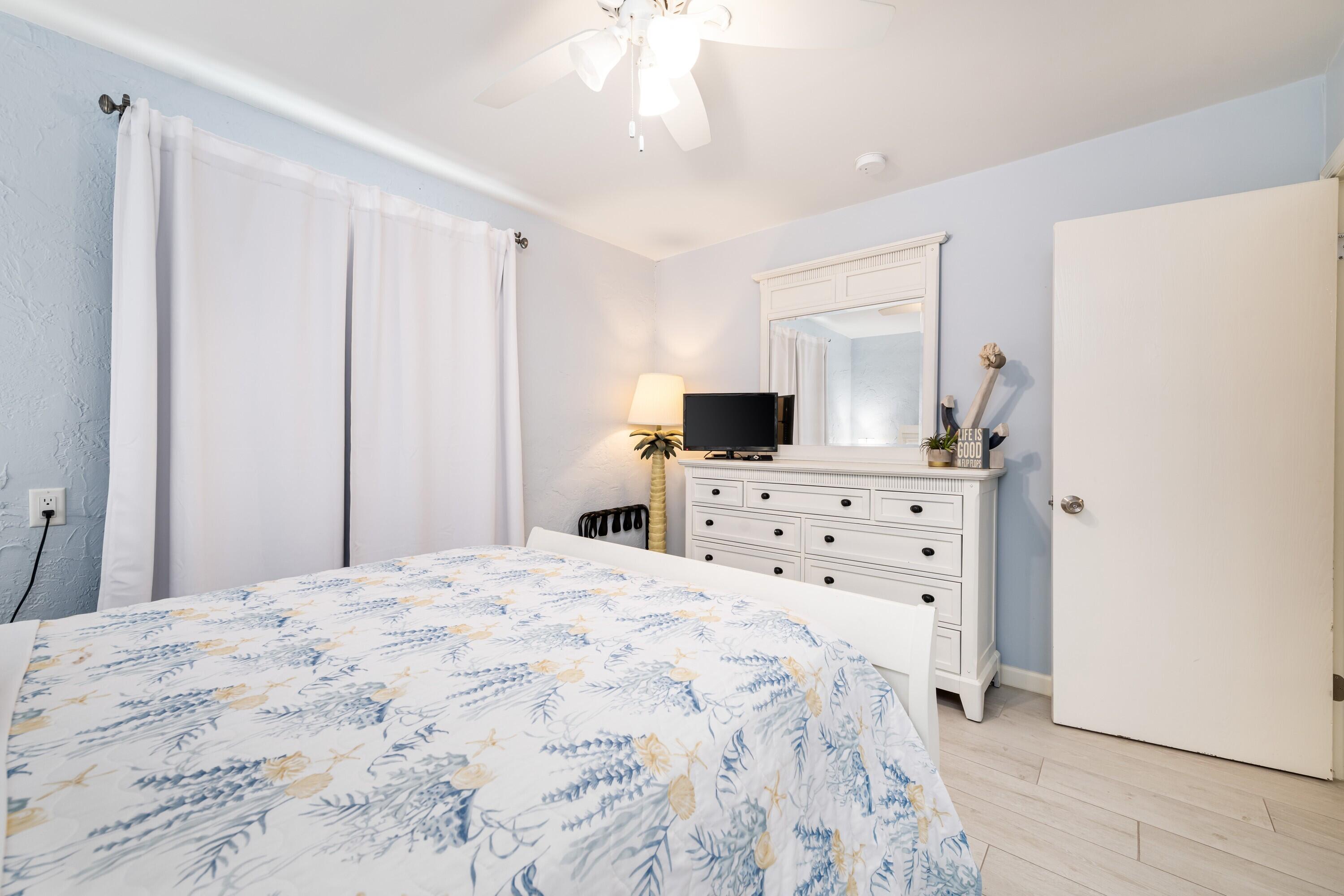 105 Ave D, Unit 101 Marathon, FL 33050 - Photo 18 of 32 a bedroom with a bed and a flat tv screen on dresser