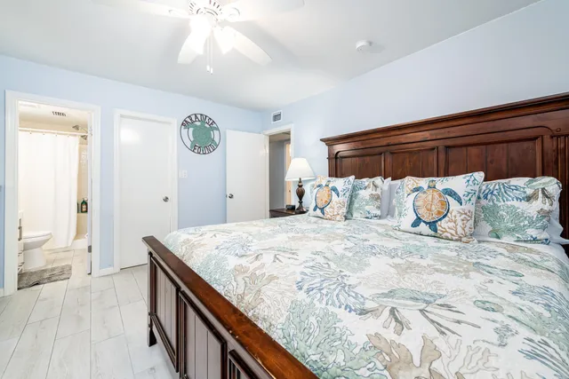 a bedroom with a bed and a flat tv screen on a dresser