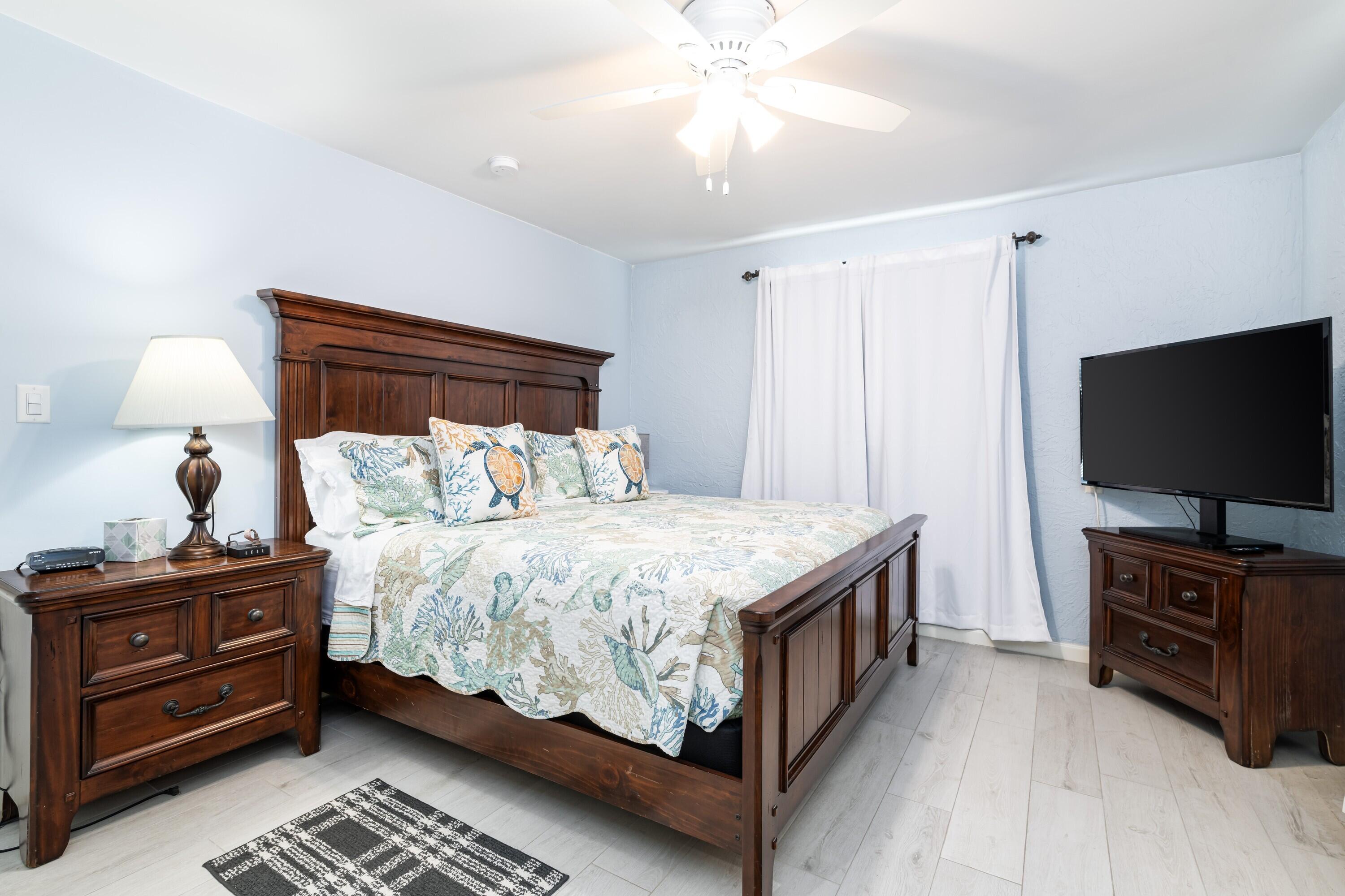 105 Ave D, Unit 101 Marathon, FL 33050 - Photo 21 of 32 a bedroom with a bed and a flat tv screen on a dresser