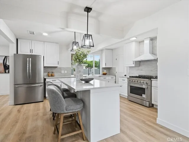 a kitchen with stainless steel appliances kitchen island granite countertop a white table and chairs