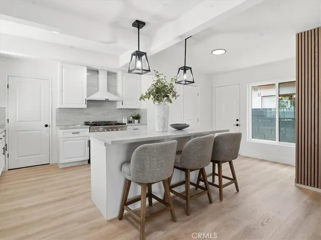 a kitchen with kitchen island a stove a sink and a refrigerator with wooden floor