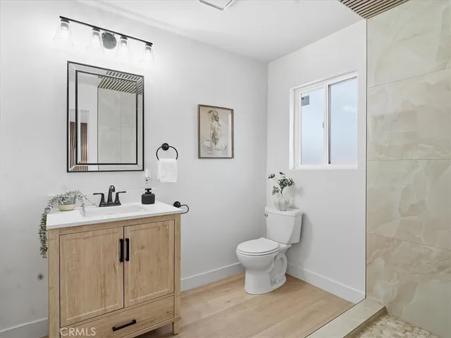 a bathroom with a sink a toilet and shower