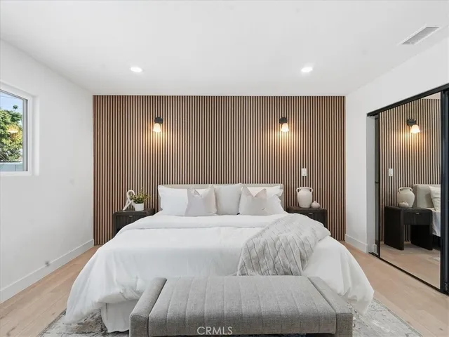 a bedroom with a bed and a large window