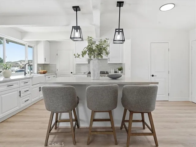 a kitchen with white cabinets and sink