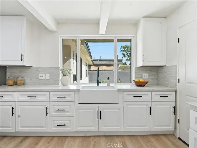 a kitchen with stainless steel appliances kitchen island granite countertop a table chairs stove and white cabinets