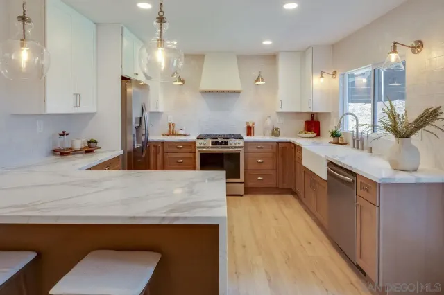 a kitchen with stainless steel appliances granite countertop a sink a stove and a refrigerator