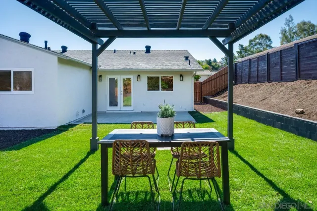 a kitchen with a dining table chairs and white cabinets