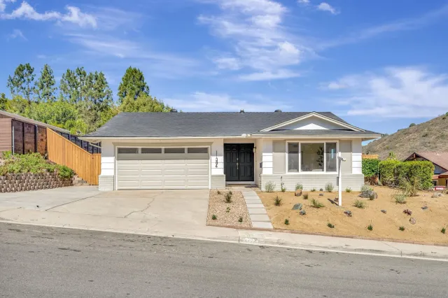 a large kitchen with kitchen island a large center island a stove a refrigerator a sink a dining table and chairs with wooden floor