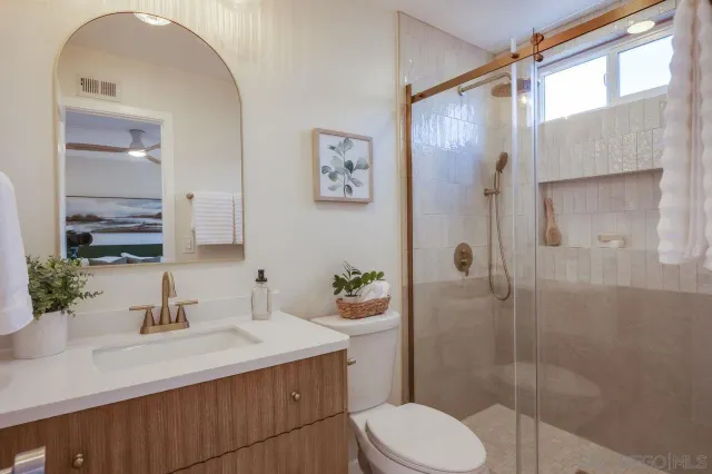 a bedroom with a large bed and a painting on the wall