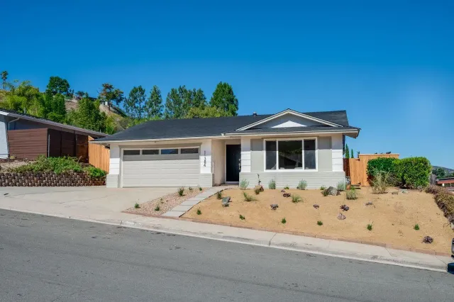 a kitchen with stainless steel appliances granite countertop a stove top oven a sink dishwasher and a refrigerator with wooden floor