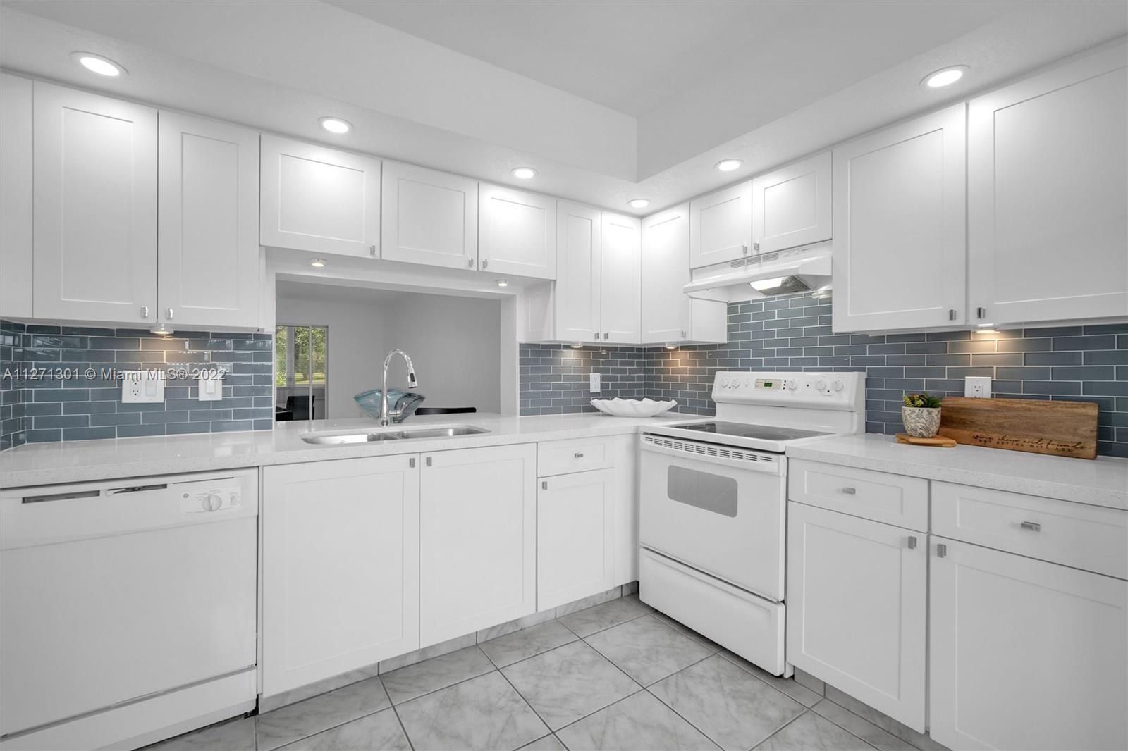 300 Southwest 130th Terrace, Unit 106B Pembroke Pines, FL 33027 - Photo 1 of 43 a kitchen with cabinets appliances a sink and a counter top space