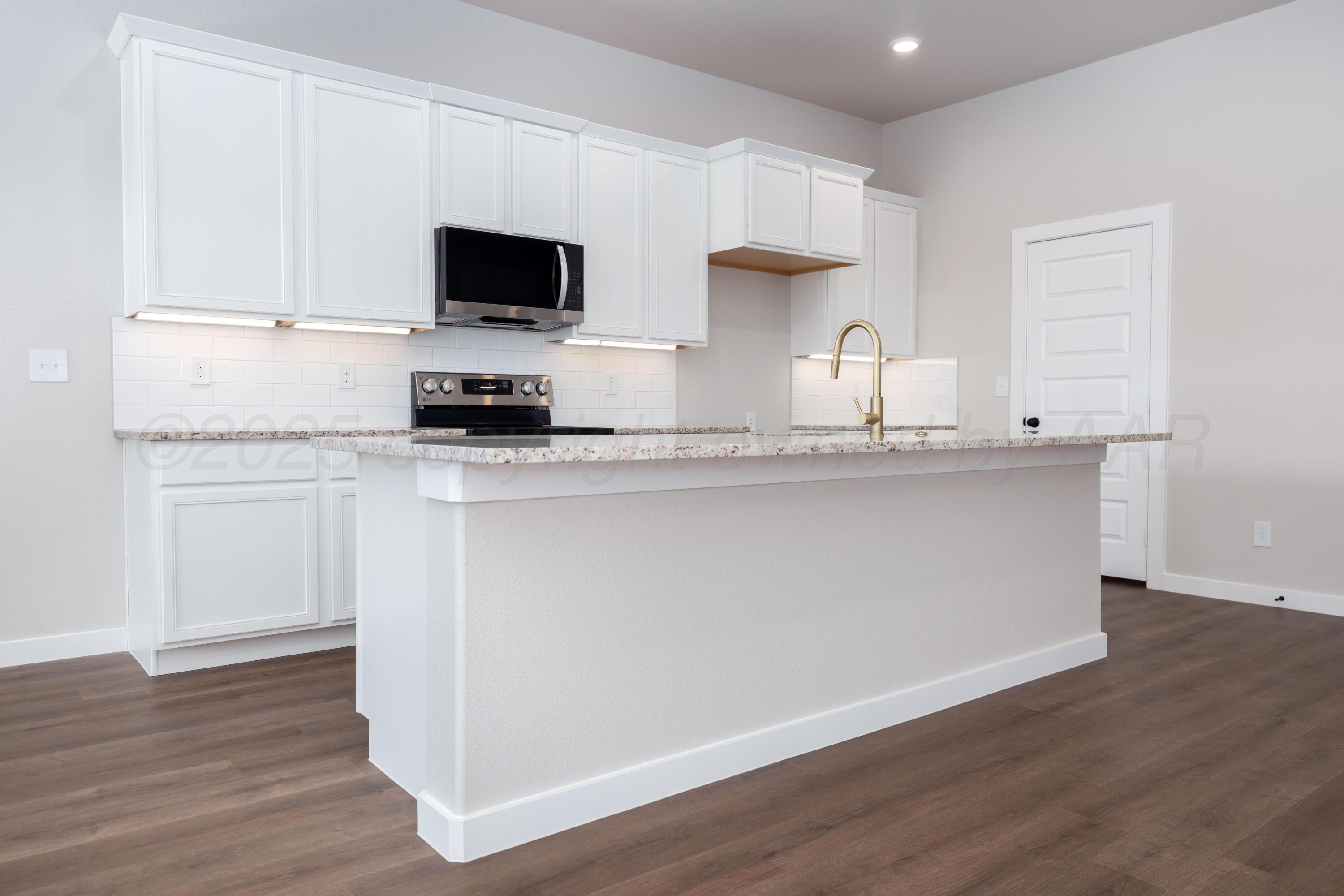 3012 Buckthorn Drive Amarillo, TX 79124 - Photo 4 of 9 a kitchen with stainless steel appliances granite countertop a sink a stove a microwave and cabinets