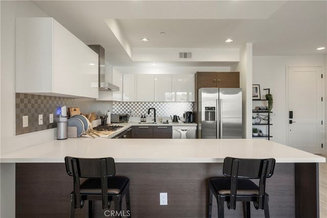 a kitchen with a dining table chairs and white cabinets