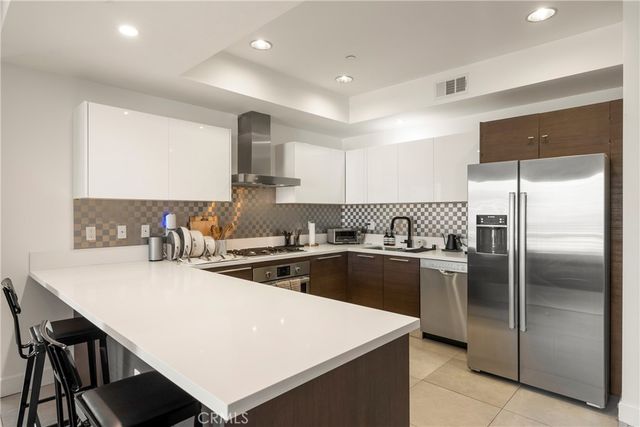 a kitchen with a sink a stove a refrigerator and white cabinets