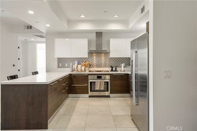 a large kitchen with stainless steel appliances granite countertop a stove and a sink