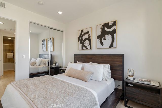 a bedroom with a bed and painting on the wall