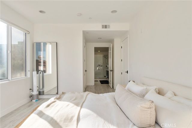 a spacious bedroom with a bed and a large mirror