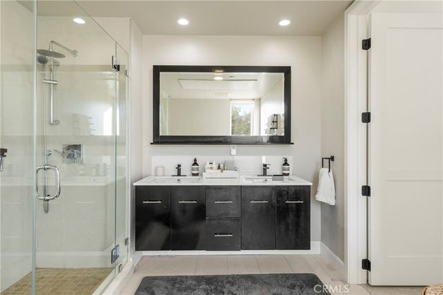 a bathroom with a double vanity sink mirror and shower