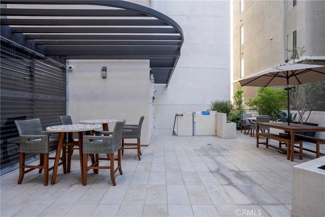 a view of a patio with a table and chairs under an umbrella