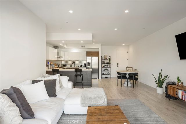 a living room with furniture and view of kitchen