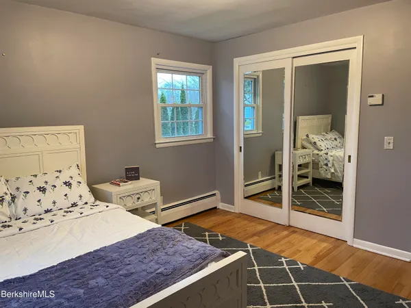 a bedroom with a bed and a mirror on a dresser