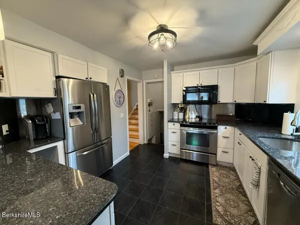 a kitchen with stainless steel appliances granite countertop a refrigerator a stove a sink and dishwasher