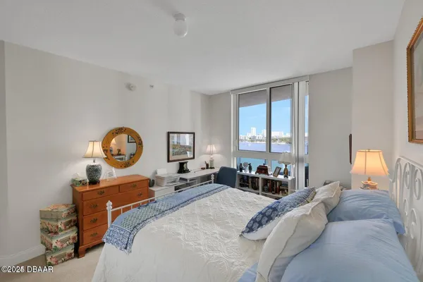 a bed room with a bed mirror and a window