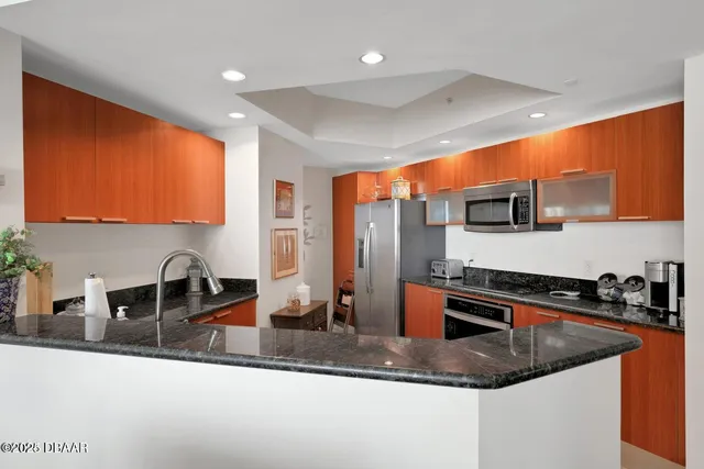 a kitchen with stainless steel appliances granite countertop sink stove and refrigerator