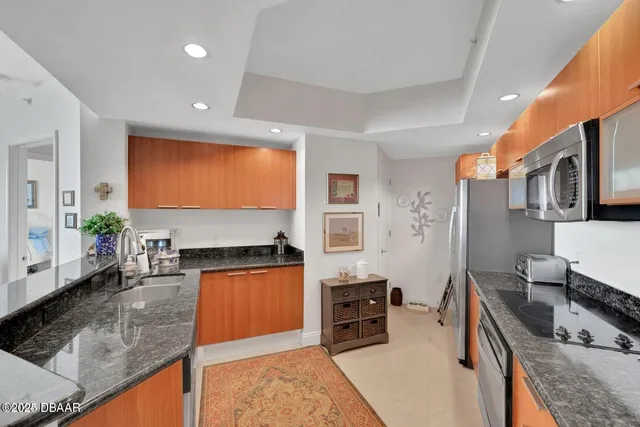 a kitchen with stainless steel appliances granite countertop sink stove top oven and cabinets
