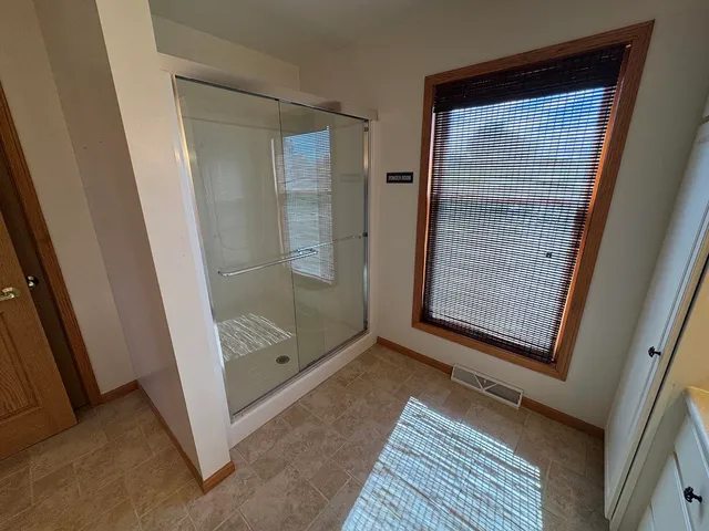 a view of an empty room with a chandelier fan