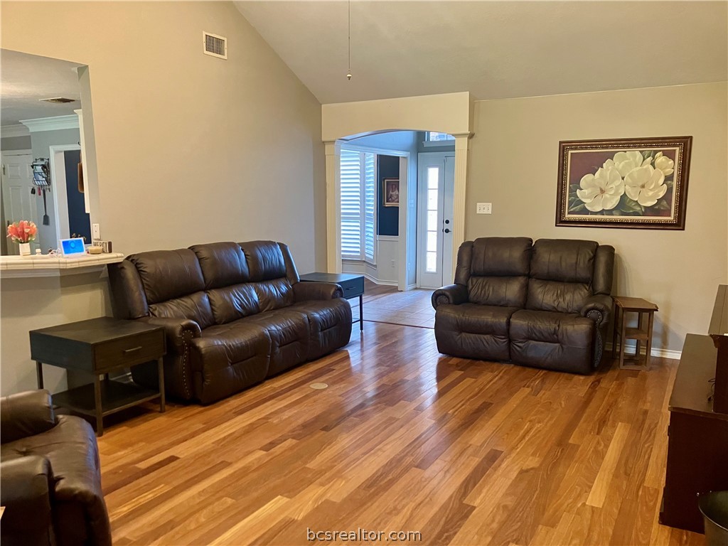 5660 Falling Water Bryan, TX 77808 - Photo 18 of 27 Living room with ornamental molding, light hardwood / wood-style flooring, decorative columns, and vaulted ceiling