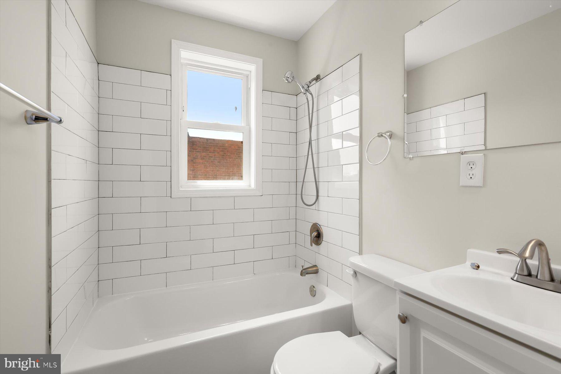 1044 Ellicott Driveway Baltimore, MD 21216 - Photo 13 of 26 a bathroom with a bathtub shower sink vanity and toilet