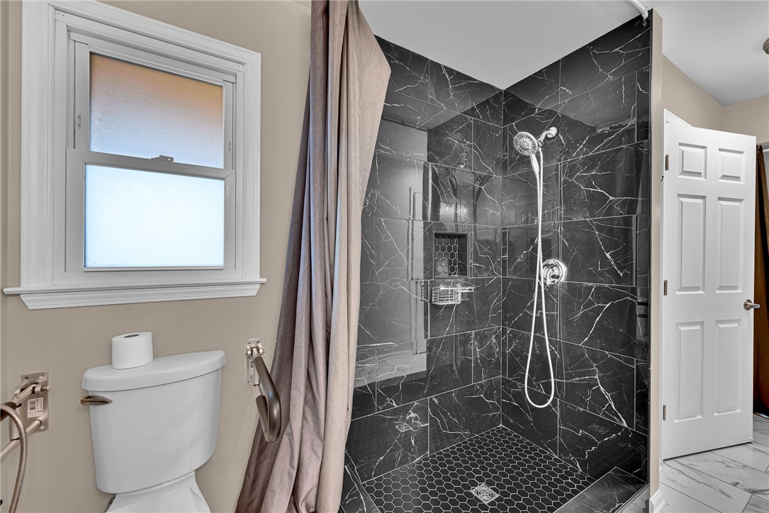 1509 Crestview Road Easley, SC 29642 - Photo 19 of 31 This bathroom features a contemporary shower with stylish dark marble-look tiling.