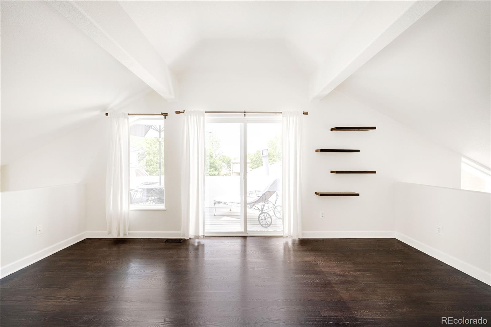 550 Madison Street Denver, CO 80206 - Photo 27 of 39 an empty room with wooden floor and windows