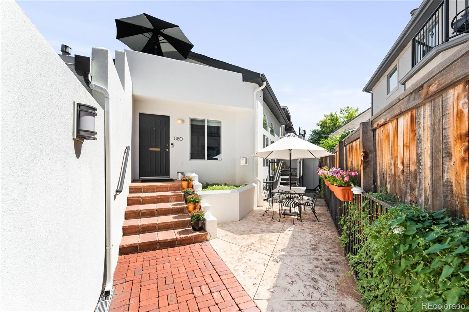 550 Madison Street Denver, CO 80206 - Photo 36 of 39 a view of a patio with table and chairs potted plants with wooden floor