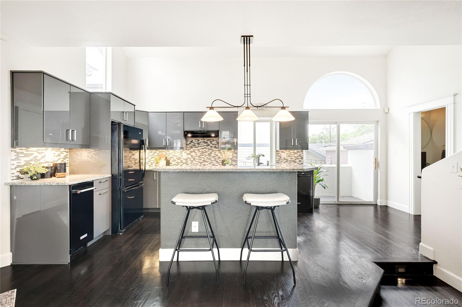 550 Madison Street Denver, CO 80206 - Photo 10 of 39 a kitchen with kitchen island granite countertop wooden floors and stainless steel appliances