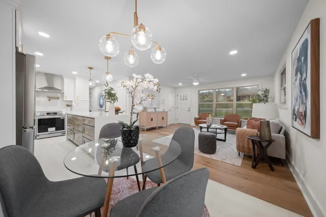 a view of a dining room with furniture a chandelier and wooden floor