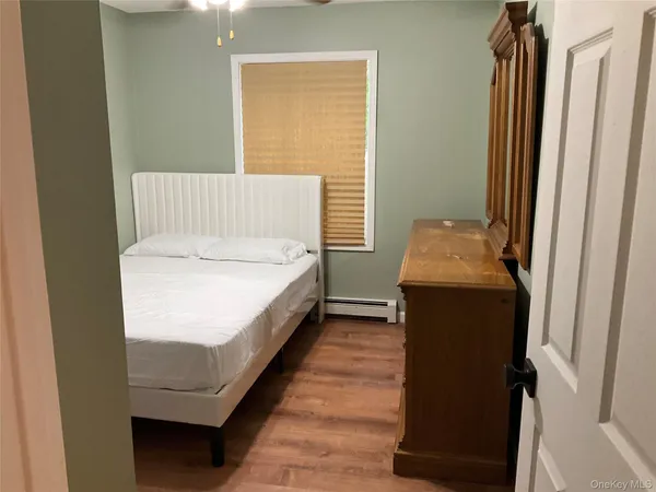 a bedroom with a bed and a wooden floor