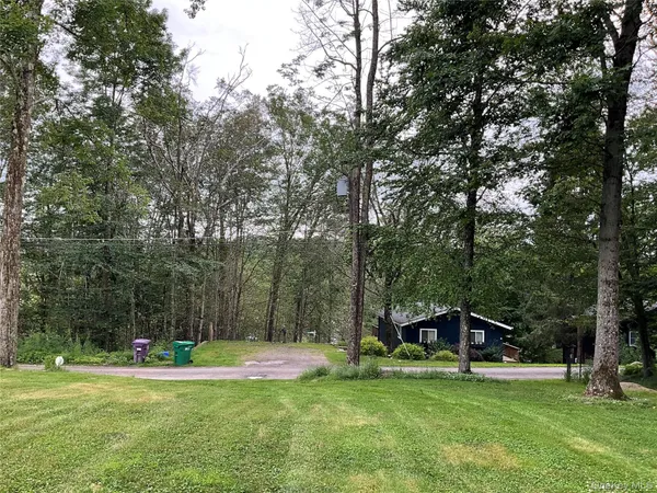 a view of a backyard with swimming pool and sitting area